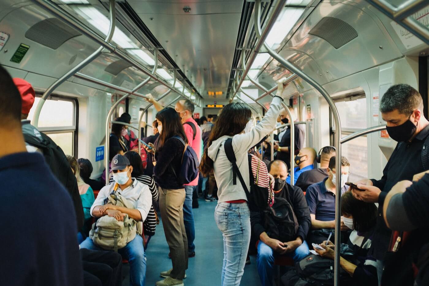 Interior of underground train with passengers riding, some seated, some standing